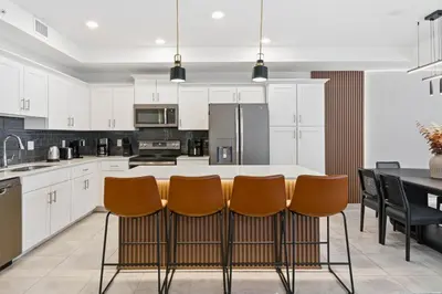 a kitchen with white cabinets and a table with chairs at 207 Storey Lake 6 Guests 2 BDRS near clubhose in Kissimmee