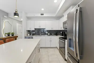 a kitchen with white cabinets and a stainless steel refrigerator at 207 Storey Lake 6 Guests 2 BDRS near clubhose in Kissimmee