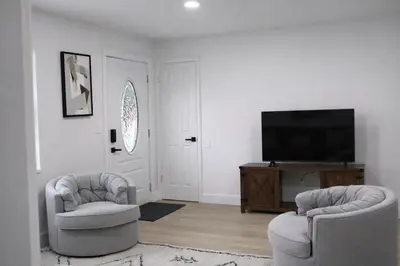 a living room with two chairs and a flat screen tv at Spacious Casselberry Home Near Attractions in Orlando