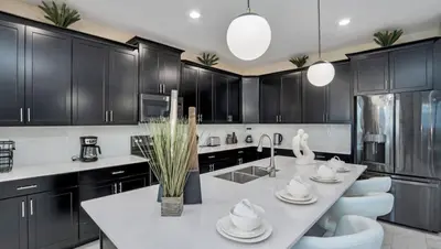 a kitchen with black cabinets and a white counter top at Pool & BBQ | Disney-Themed Cozy 6BD | Near Disney in Kissimmee