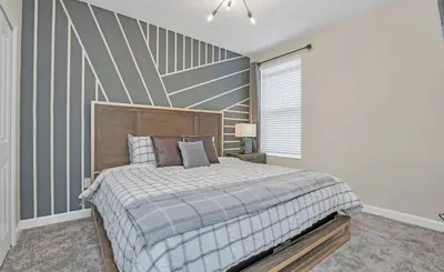 a bedroom with a bed and a striped wall at Pool & BBQ | Disney-Themed Cozy 6BD | Near Disney in Kissimmee