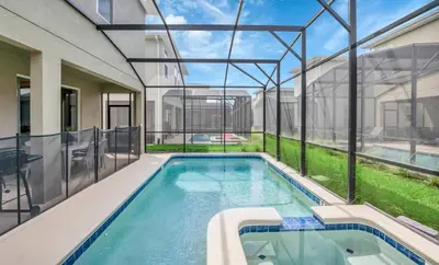 an indoor swimming pool in a house with glass walls at Pool & BBQ | Disney-Themed Cozy 6BD | Near Disney in Kissimmee