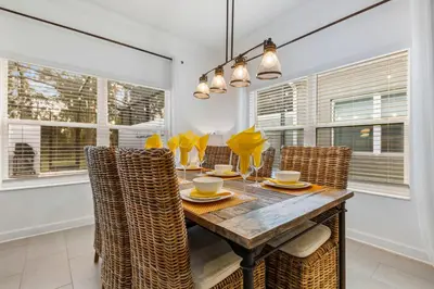 a dining room with a wooden table and chairs at South-Facing Pool 5BR Storey Lake Lazy River 2437 in Kissimmee