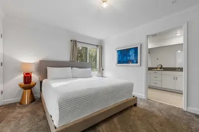 a white bedroom with a bed and a kitchen at South-Facing Pool 5BR Storey Lake Lazy River 2437 in Kissimmee