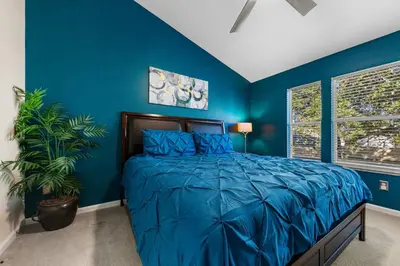 a blue bedroom with a bed and a plant at Private Pool 3BR Resort Villa near Disney in Kissimmee