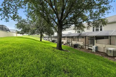 a building with a tree in front of a yard at Private Pool 3BR Resort Villa near Disney in Kissimmee