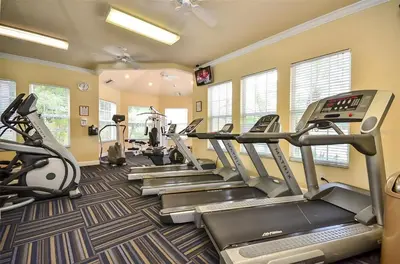 a fitness room with treadmills and elliptical machines at Private Pool 3BR Resort Villa near Disney in Kissimmee