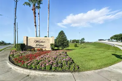 a sign at the entrance to a park with flowers at Private Pool 3BR Resort Villa near Disney in Kissimmee