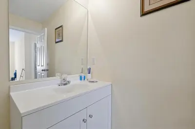 a white bathroom with a sink and a mirror at 4BR Luxury Villa Private Pool & Slide Disney in Kissimmee