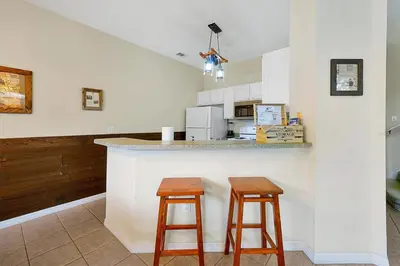 a kitchen with a counter and two stools at 4BR Luxury Villa Private Pool & Slide Disney in Kissimmee