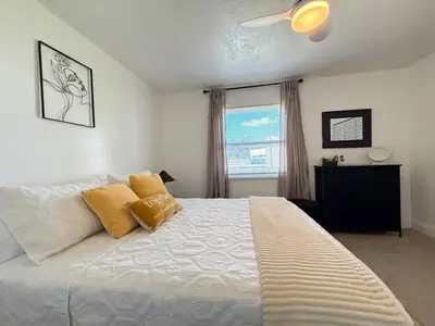 a bedroom with a large white bed with yellow pillows at Family Pool Home |Close to Disney/Universal/Epic in Kissimmee