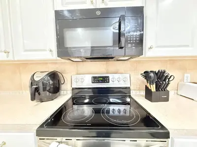a kitchen with a stove and a microwave at Family Pool Home |Close to Disney/Universal/Epic in Kissimmee