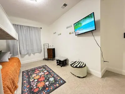 a living room with a flat screen tv on a wall at Family Pool Home |Close to Disney/Universal/Epic in Kissimmee