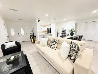 a living room with a white couch and a kitchen at Family Pool Home |Close to Disney/Universal/Epic in Kissimmee