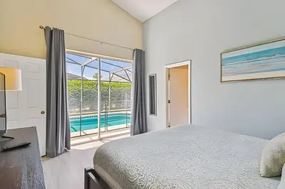 a bedroom with a bed and a view of a pool at Casa aconchegante em Glenbrook perto da Disney in Orlando