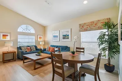 a living room with a table and a blue couch at Casa aconchegante em Glenbrook perto da Disney in Orlando