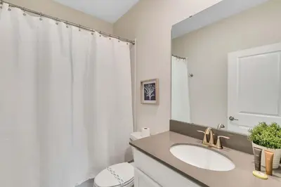 a bathroom with a sink and a toilet and a mirror at Classy 6BR Home with Private Pool in Kissimmee