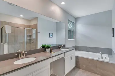 a bathroom with two sinks and a tub at Classy 6BR Home with Private Pool in Kissimmee