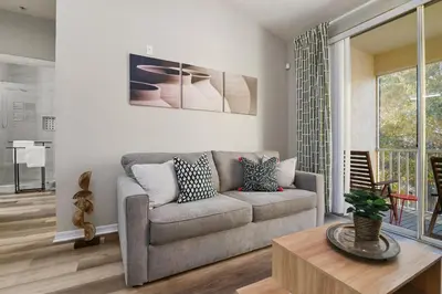 a living room with a couch and a table at Restpool vibes, Nest tree-ish Retreat- NxtDisney in Kissimmee