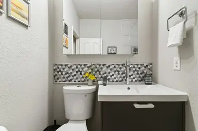 a bathroom with a white toilet and a sink at Restpool vibes, Nest tree-ish Retreat- NxtDisney in Kissimmee