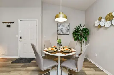 a white dining room with a table and chairs at Restpool vibes, Nest tree-ish Retreat- NxtDisney in Kissimmee