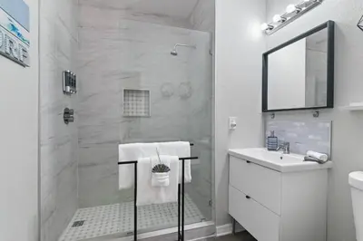 a white bathroom with a shower and a sink at Pause Discover something that nourishes your soul in Kissimmee