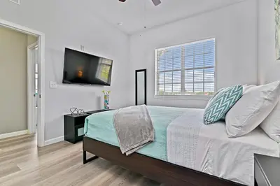 a bedroom with a bed and a flat screen tv at Sunset every single day ReserveView 4BRElevator in Kissimmee