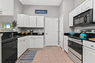a kitchen with white cabinets and black appliances at Sunset every single day ReserveView 4BRElevator in Kissimmee