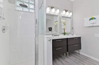 a white bathroom with a sink and a shower at Finest renovated w Pool, Game rm, 4 Mi to Disney in Kissimmee