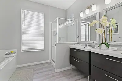 a white bathroom with a sink and a mirror at Finest renovated w Pool, Game rm, 4 Mi to Disney in Kissimmee