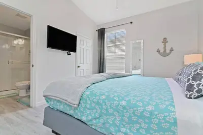 a bedroom with a bed and a flat screen tv at Finest renovated w Pool, Game rm, 4 Mi to Disney in Kissimmee