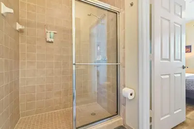 a bathroom with a shower with a glass door at SPECTACULAR CONDO only 4 Miles to Disney! in Kissimmee