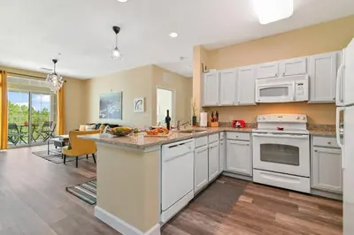 a kitchen with white cabinets and a counter top at SPECTACULAR CONDO only 4 Miles to Disney! in Kissimmee