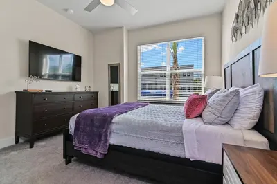 a bedroom with a bed and a tv and a window at Look Out over Nature - Unique FRESH Corner Home in Orlando