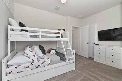 a white bunk bed in a room with a tv at Discover paradise - NEW! Pool House Next to Disney in Orlando