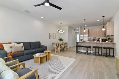 a living room with a blue couch and a kitchen at Discover paradise - NEW! Pool House Next to Disney in Orlando