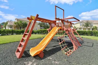 a playground with an orange slide and a ladder at Oasis NEW Townhome Splash Pool Nature-Infused in Orlando