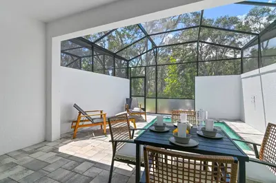 a glass house with a table and chairs on a patio at Oasis NEW Townhome Splash Pool Nature-Infused in Orlando