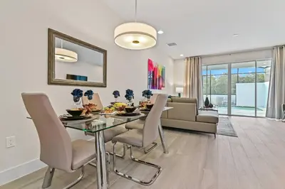 a dining room with a table and chairs and a couch at Discover Your Escape - NEW house wPrivate Pool in Orlando
