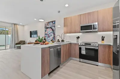 a kitchen with stainless steel appliances and wooden cabinets at Discover Your Escape - NEW house wPrivate Pool in Orlando