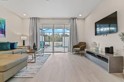 a living room with a couch and a tv at Discover Your Escape - NEW house wPrivate Pool in Orlando