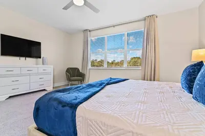 a bedroom with a bed and a tv and a window at Happiness is a destination ! - NEW house with pool in Orlando