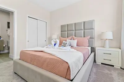 a bedroom with a large bed with pink pillows at Happiness is a destination ! - NEW house with pool in Orlando