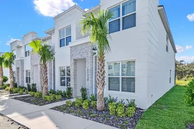 a white house with palm trees in front of it at Happiness is a destination ! - NEW house with pool in Orlando