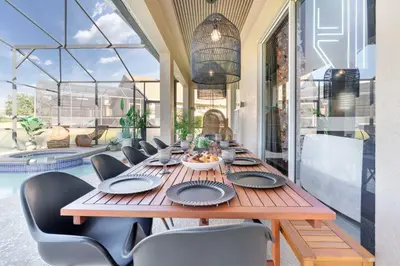 a long wooden table with chairs and a bowl of food at New Modern STAR WARS Villa Only 3 Miles 2 Disney w VR's in Kissimmee