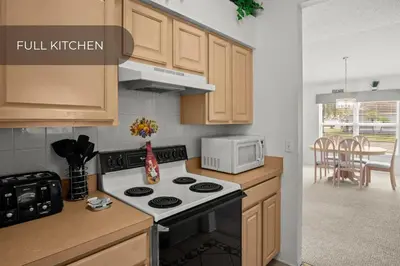 a kitchen with a stove and a microwave at Cozy 3BR Family Home Minutes from Disney in Kissimmee