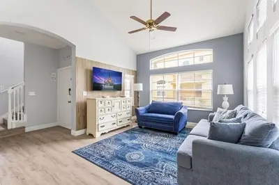 a living room with a blue couch and a tv at Casa 4Q Comfort Resort‑Style em Emerald Island in Kissimmee