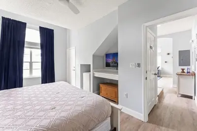 a white bedroom with a bed and a tv at Casa 4Q Comfort Resort‑Style em Emerald Island in Kissimmee
