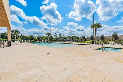 a swimming pool at a resort with palm trees at Brand New Home with 4 En-Suites, near Disney in Kissimmee