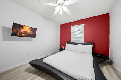 a bedroom with a bed with a red wall at Amazing 08 BdrmsSleeps 14Pool in Kissimmee